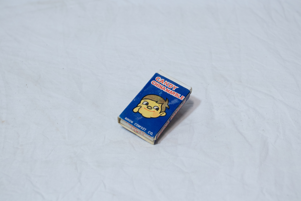 Stellebord til dukke. Rødmalt trekonstruksjon av runde pinner, tappet sammen i kryss i bena. Kan slås sammen. Badekar naglet fast i trerammen, laget av plast/vinyl. Badekaret har propp med slange i bunnen. Stellematte kan legges oppå badekaret, denne er laget i bomull. Stellematte stives av ved to lærstropper under, disse er spikret fast. Påfestet bærhåndtak i toppen av metall, skrudd med to skruer. På ene siden ett stykke med lysblå plast med tre lommer, hele stykket og lommene er kantet med rødrutete stoff.