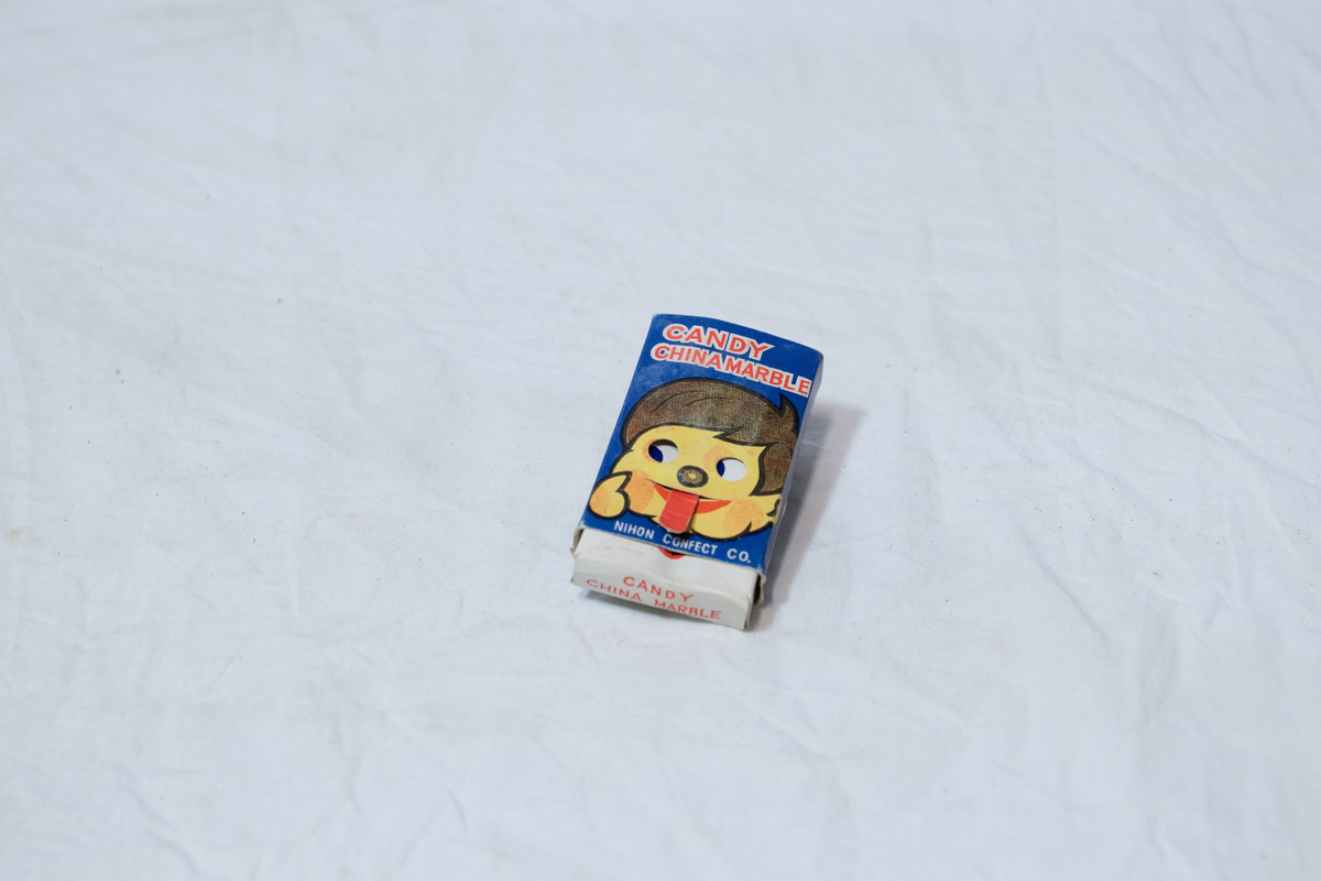 Stellebord til dukke. Rødmalt trekonstruksjon av runde pinner, tappet sammen i kryss i bena. Kan slås sammen. Badekar naglet fast i trerammen, laget av plast/vinyl. Badekaret har propp med slange i bunnen. Stellematte kan legges oppå badekaret, denne er laget i bomull. Stellematte stives av ved to lærstropper under, disse er spikret fast. Påfestet bærhåndtak i toppen av metall, skrudd med to skruer. På ene siden ett stykke med lysblå plast med tre lommer, hele stykket og lommene er kantet med rødrutete stoff.