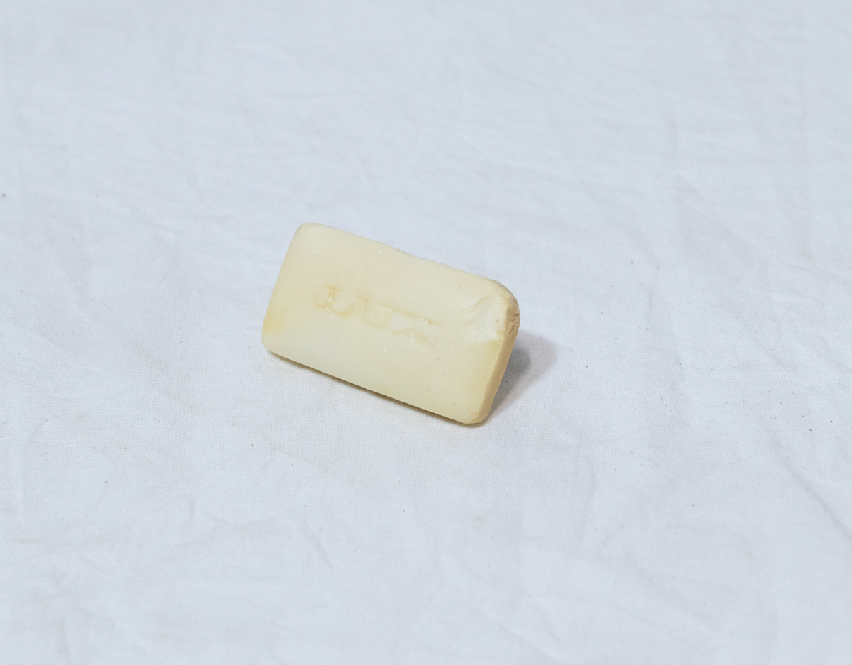 Stellebord til dukke. Rødmalt trekonstruksjon av runde pinner, tappet sammen i kryss i bena. Kan slås sammen. Badekar naglet fast i trerammen, laget av plast/vinyl. Badekaret har propp med slange i bunnen. Stellematte kan legges oppå badekaret, denne er laget i bomull. Stellematte stives av ved to lærstropper under, disse er spikret fast. Påfestet bærhåndtak i toppen av metall, skrudd med to skruer. På ene siden ett stykke med lysblå plast med tre lommer, hele stykket og lommene er kantet med rødrutete stoff.