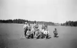 Fløterlag med ti menn fotografert i ei tørrlagt, langgrunn o