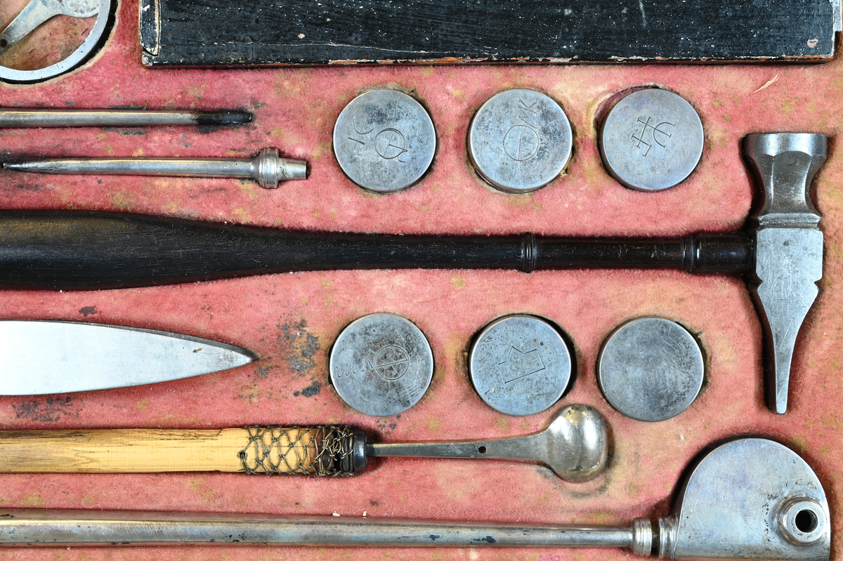 Reagensbestick för blåsrörsanalys, i fodral av trä. Lösa delar: isärtagbart blåsrör av silver, troligen av Bergmans typ, två blåsrörsmunstycken av silver, liten degel av silver med vridbart lock och skaft av trä, hammare med skaft av ebenholts, ring av stål till kross, sex reagensdosor av silver, med lösa lock med kemiska tecken, enligt Scheffer-Bergman jämte reagens (kalkspat, gips, borax (?), salpeter (?), alkalisalt), pincett av silver med "kattfot" och "B 2" END B=S:t Erik? (=1784), två stavmagneter med två armeringsjärn och trästav i fodral av papp och trä, fodral, skjutlåda, blåsrör av mässing av Berzelius typ. Kvadratisk stöd av stål och nyckel till fodralet och skjutlådan saknas. Måtten avser fodralet.