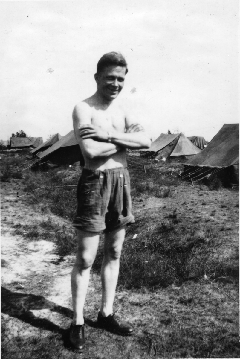Ein ung mann i kortbukse og sko. Fotografert i tilknyting til invasjonen i Normandie.