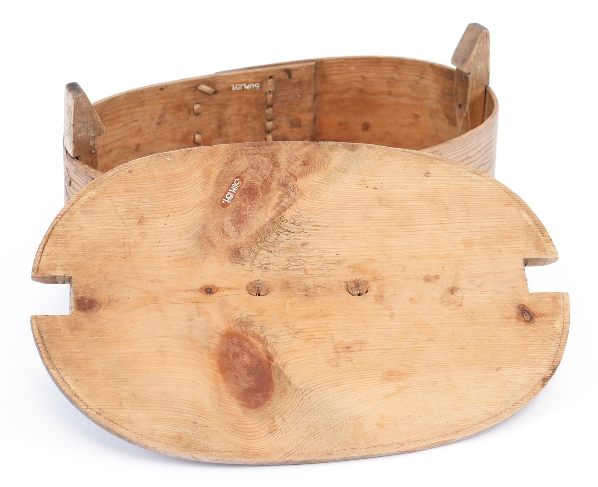 Sveipet tine laga av furu. Oval form med to vertikale faste stolpar på innsida og flatt lokk som kan takast av ved å presse det mot stolpen. Sveipen sydd samman med tæger, botnen festa med naglar. På lokket stort, halvsirkelformet trehandtak laga av lauvtre og utskore pil teikn for å visa trykkeretning. Tina umåla.