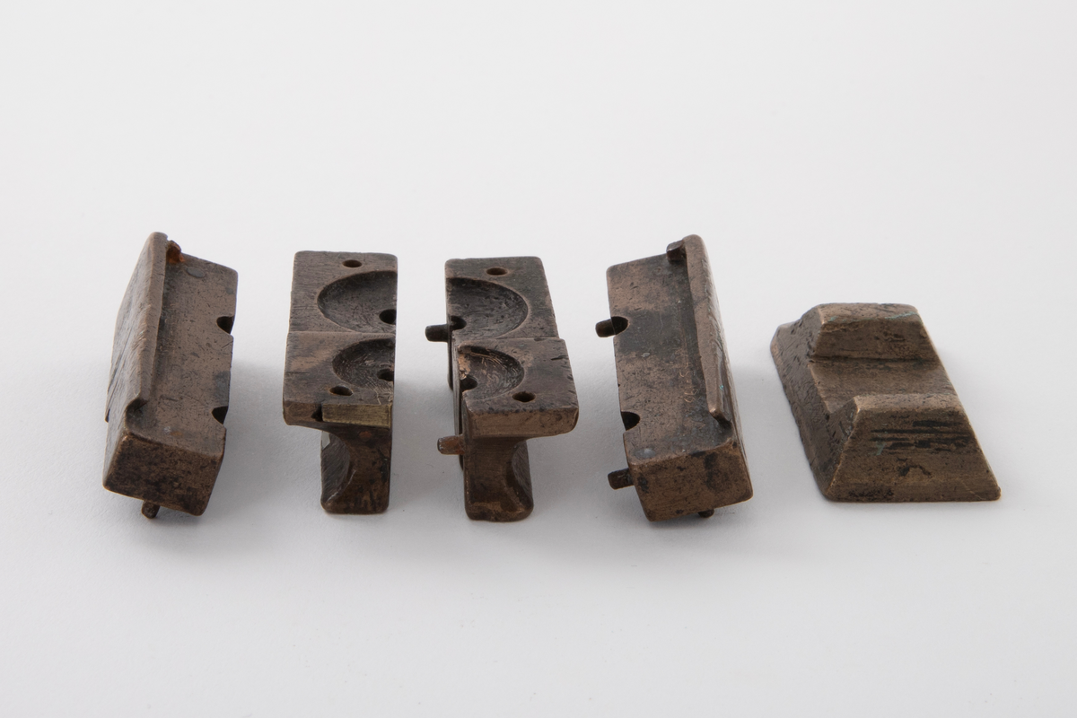 Støpeform for støping av stettknapper i to størrelser. Støpeformen er av bronse og i fem deler.