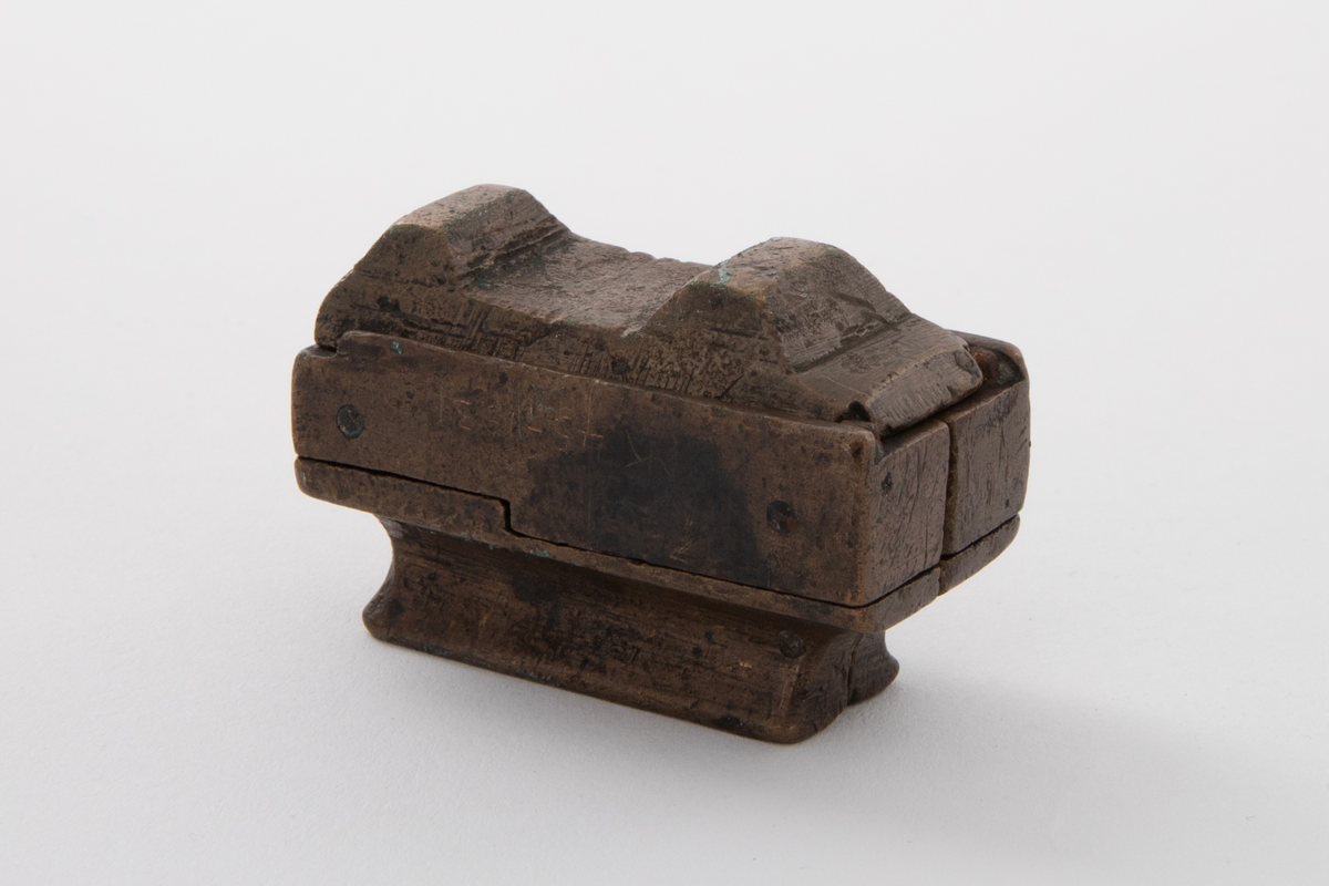 Støpeform for støping av stettknapper i to størrelser. Støpeformen er av bronse og i fem deler.