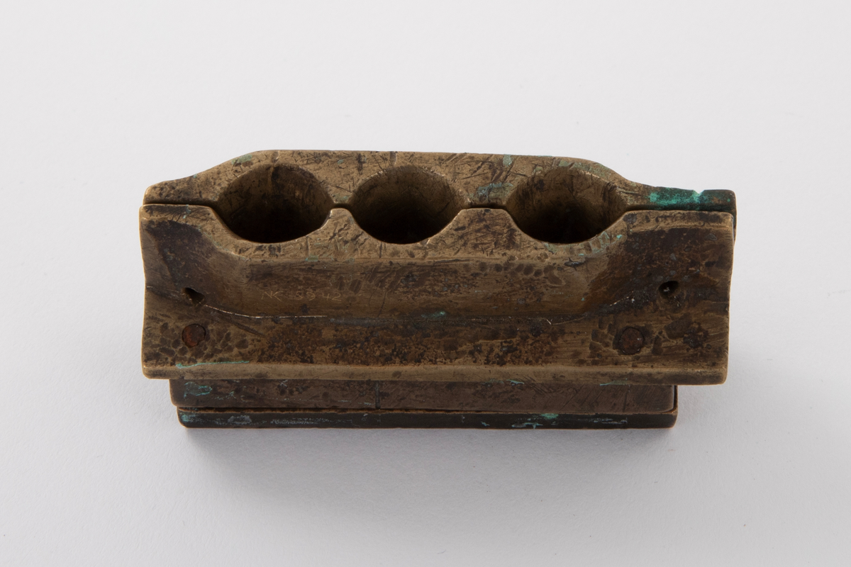 Støpeform for støping av tre stettknapper i ulik størrelse, med stjerneformet rosett i forskjellige former. Støpeformen er av bronse og i fem deler.