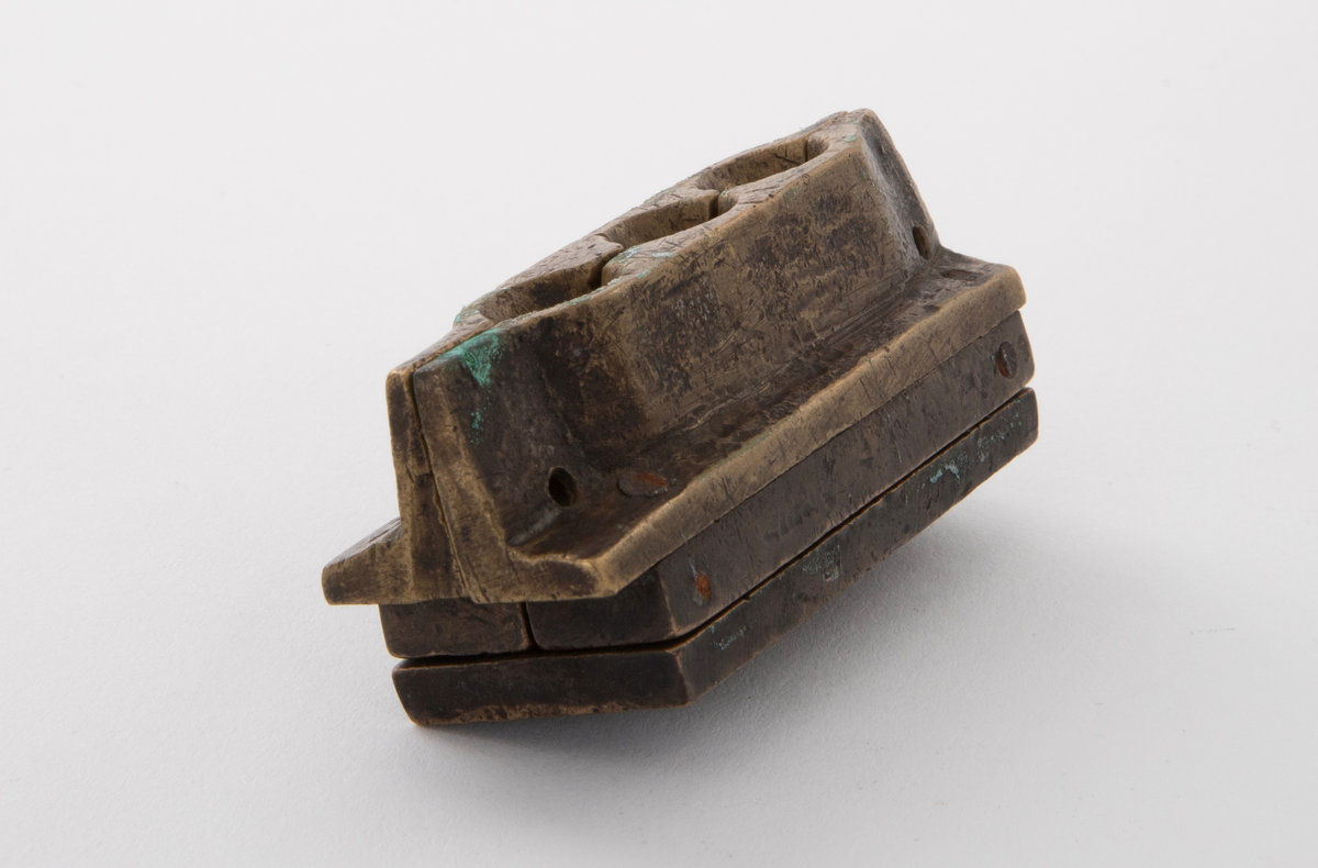 Støpeform for støping av tre stettknapper i ulik størrelse, med stjerneformet rosett i forskjellige former. Støpeformen er av bronse og i fem deler.