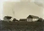 Ytterligare en bild från söder. Bakbygget är uppfört, det var det inte 1906, se Bild 921. Annars är det sig likt. Stora halm(?)stackar står bakom ladugården. Det måste ha varit en mycket god skörd det året, om man inte kunde få plats med allting inne på det mycket stora loftet. Har man tvättat mattor? Det ser ut att hänga mattor på slantunen!