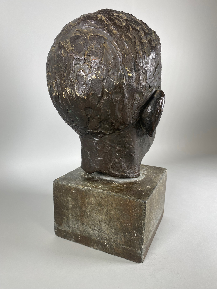 Bronsebyste av Nils Christian Clausen (1869-1942). Festet med en lang skrue til en sokkel av stein med navneplate.