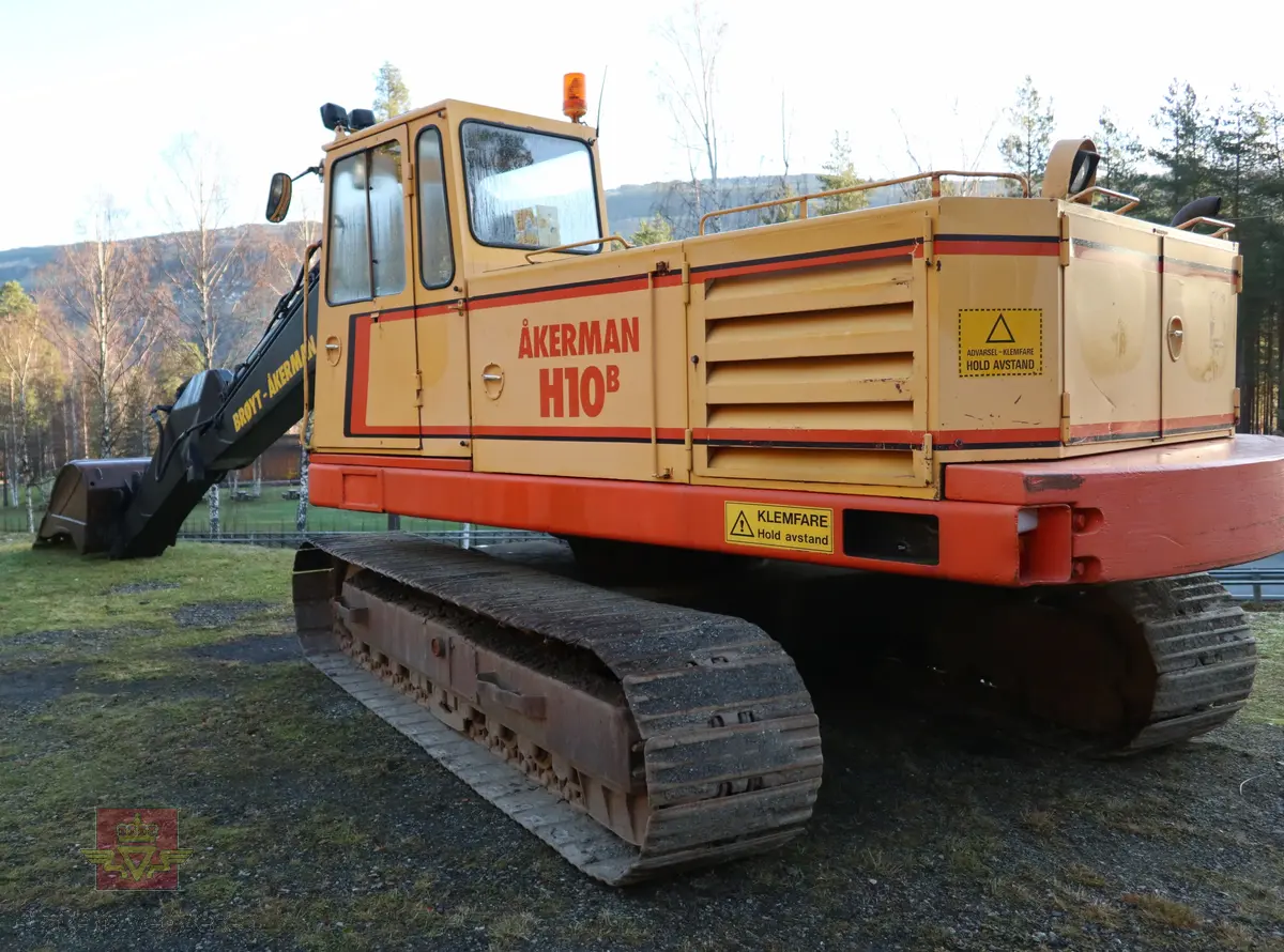 Åkerman H10B gravemaskin. Beltegående. Gul, rød, og svart. Merking fra produsent og første bruker. Maskina har en dieseldrevet Volvo Penta TD61ACE motor, den yter 166 Hk (122 kW). Motoren er 6-sylindret, 4-takt, med vannavkjøling, direkte innsprøytning og turbo. Det elektriske systemet er 24V. Drivstofftanken rommer 340 liter. Lydnivået er 77dB (målt 10 meter fra maskinen). Serienummer er 2632.
Maskinen har gått 10.000 arbeidstimer.