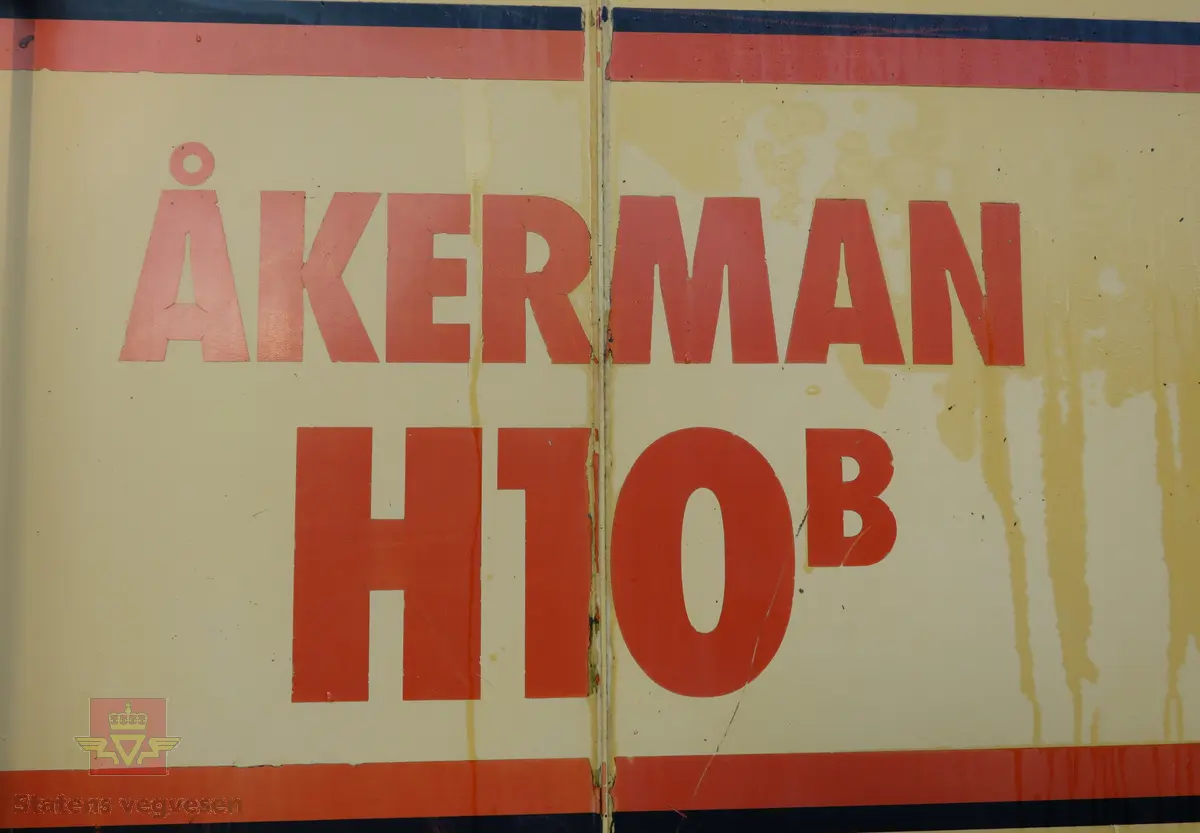 Åkerman H10B gravemaskin. Beltegående. Gul, rød, og svart. Merking fra produsent og første bruker. Maskina har en dieseldrevet Volvo Penta TD61ACE motor, den yter 166 Hk (122 kW). Motoren er 6-sylindret, 4-takt, med vannavkjøling, direkte innsprøytning og turbo. Det elektriske systemet er 24V. Drivstofftanken rommer 340 liter. Lydnivået er 77dB (målt 10 meter fra maskinen). Serienummer er 2632.
Maskinen har gått 10.000 arbeidstimer.