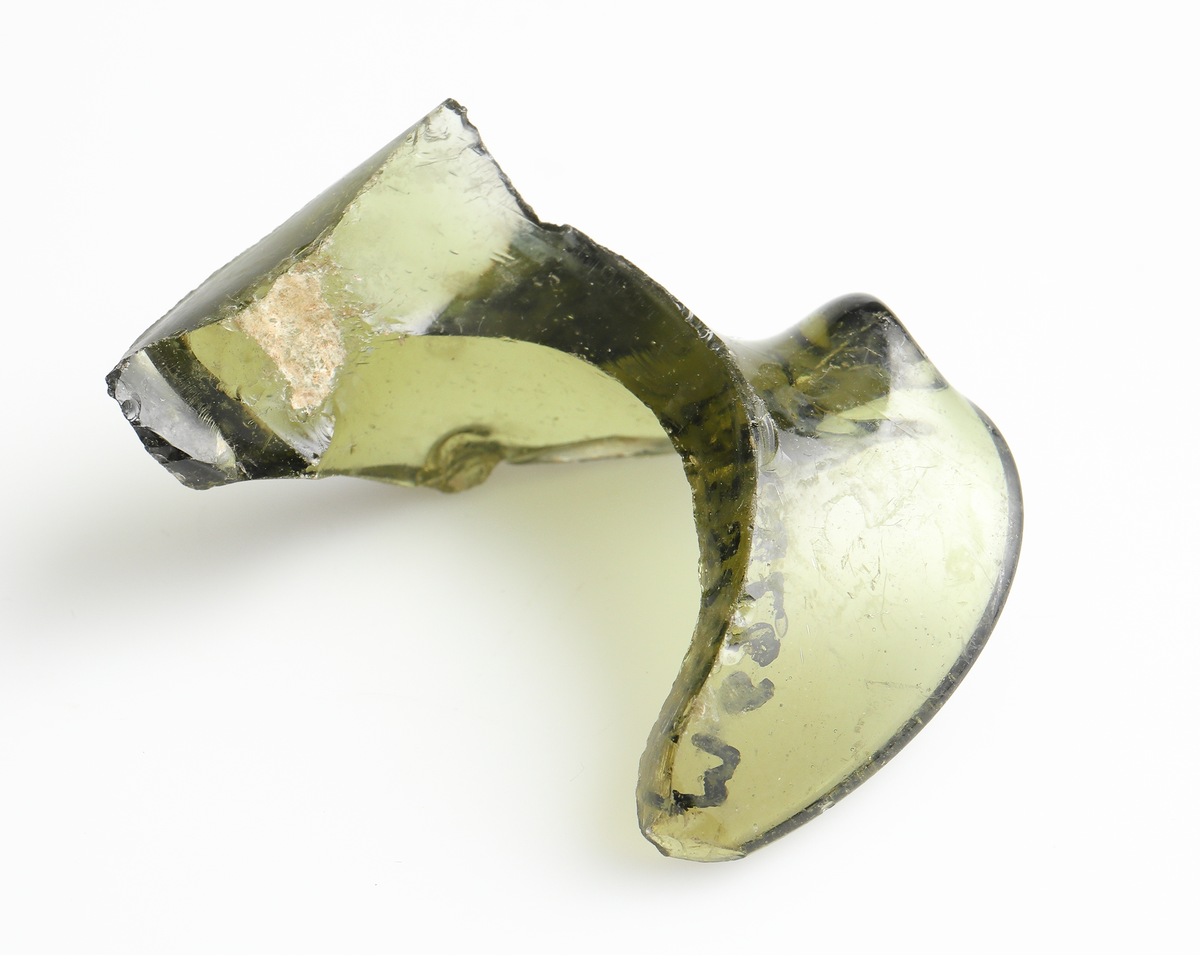 Två veckade glasfragment av grön glasmassa. Möjligen en form av mynning, eller en veckad krage till en flaska?