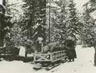 Män ur trängtrupperna lastar lådor på en släde i en snöklädd skog.