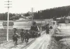 Cykeltolkning bakom bandvagn på landsväg.