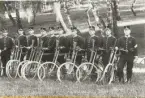 Velocipedavdelning uppställd i en trädbevuxen backe med gevär m/1896 hängande från cykelstyret, ca 1900.