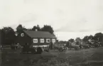 Stridsvagnar m/1921 parkerade på fält vid ett hus.