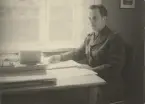 Soldat sitter vid ett skrivbord och läser dokument, 1940-talet.