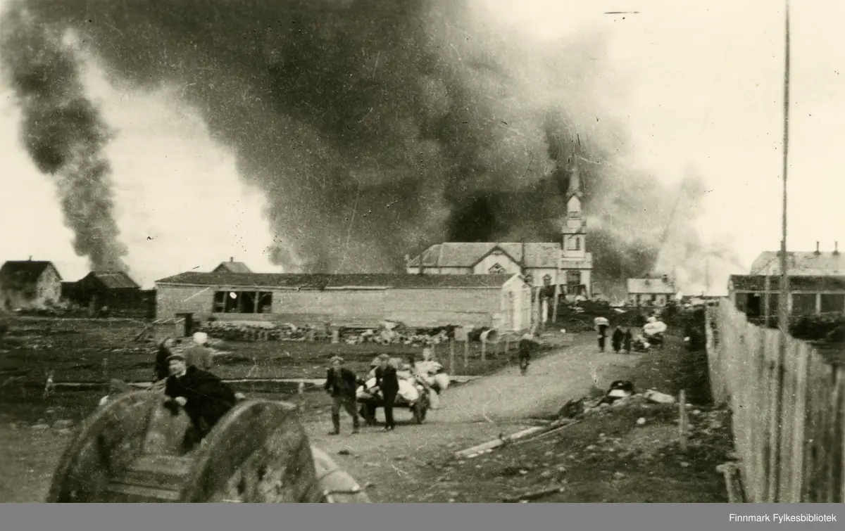 Sivile evakuerer oppover Fosseveien fra Vadsø etter at byen er satt i brann under omfattende sovjetisk flyangrep 23. august 1944..