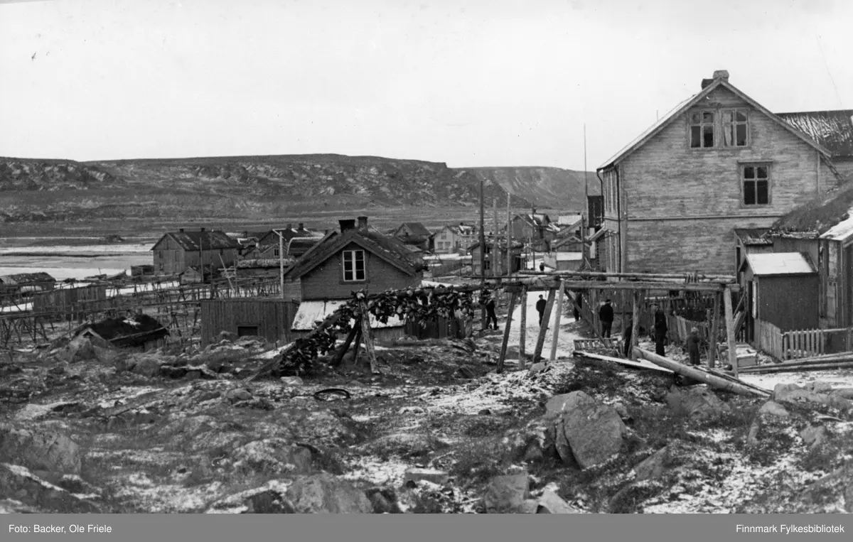 Parti av bygda Hamningberg sett fra øst. Det store bygget i forgrunnen var bygdas post og telegraf. Huset med bislag helt til høyre var eid av Høyen. Det brant ned på 1950-tallet.