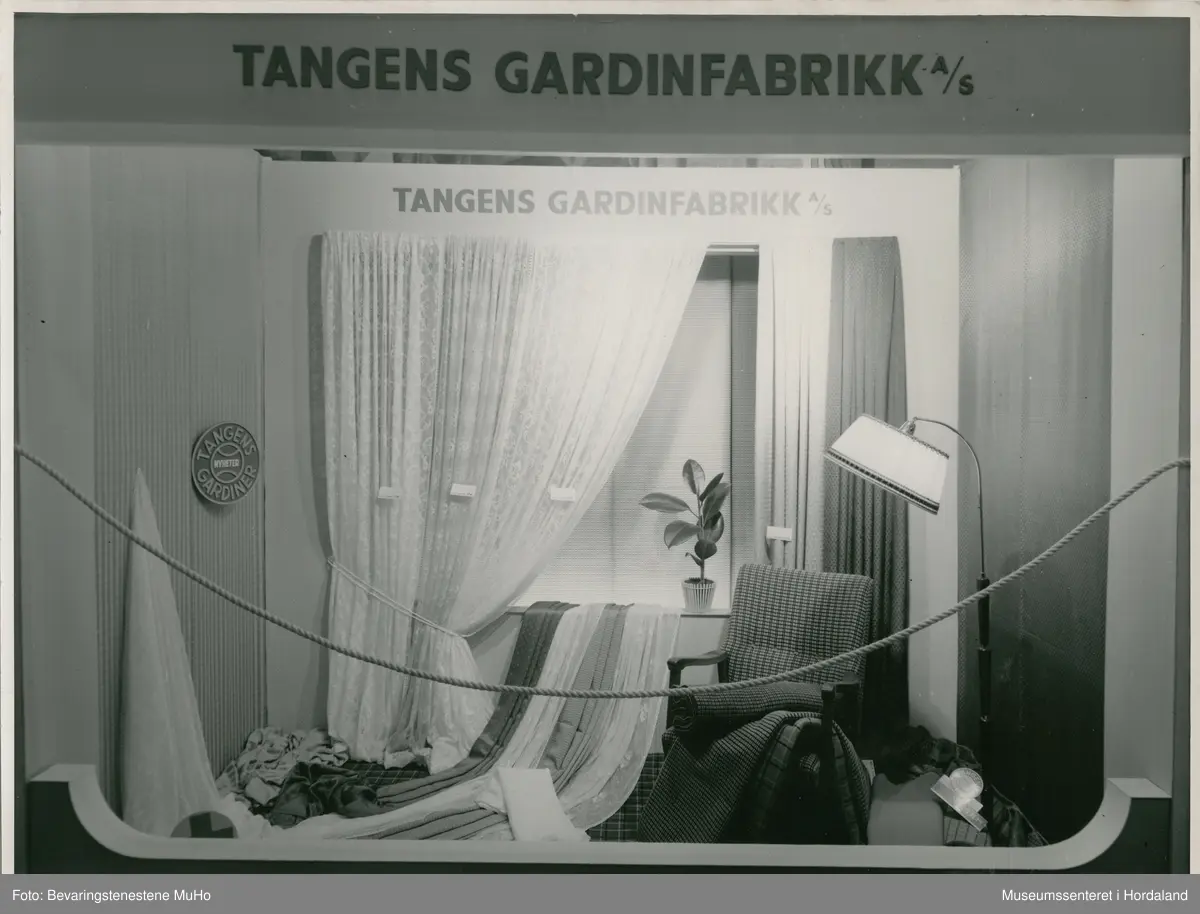 Utstillingsfoto frå Tangens Gardinfabrikk, Bergen. Foto frå ulike messe- og vindaugsutstillingar på 1920- til 60-talet. Bileta viser utstillingar av gardiner og møbelstoff frå bergensbedrifta.