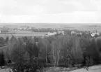 Del av Linköping från Galgbergets höjder. Foto 1893 och med kameran riktad närmast rakt österut. På höjden närmast bildens betraktare ses från vänster fastigheterna Högsätter, Carlsborg, Högtomta och Gustafsberg. Bortom ringlar Tinnerbäcken djupt skuren i landskapet mot Tinnerbäckslyckorna i bildens väntra kant. Den sällan avbildade spången över bäcken från staden mot dess omland anas framför bebyggelsen.