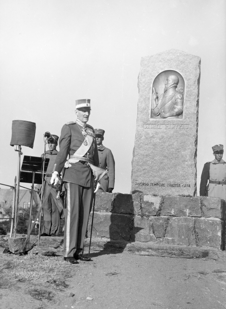 Prins Carl inviger monumentet över danske fältherren Daniel Rantzau den 26 juni 1938. Prinsen står vid minnesstenen med några militärer i bakgrunden. På plats fanns också prins Harald av Danmark. Utöver att vara till åminnelse av Ranzau, som stupade på denna klippa i striden om Varbergs fästning den 11 november 1569, var tanken också denna som prins Carl uttryckte vid avtäckningen: "Men måtte också vår gemensamma minnessten i alla tider kunna bära vittnesbörd om att fred råder och alltid skall råda mellan Danmarks och Sveriges folk."