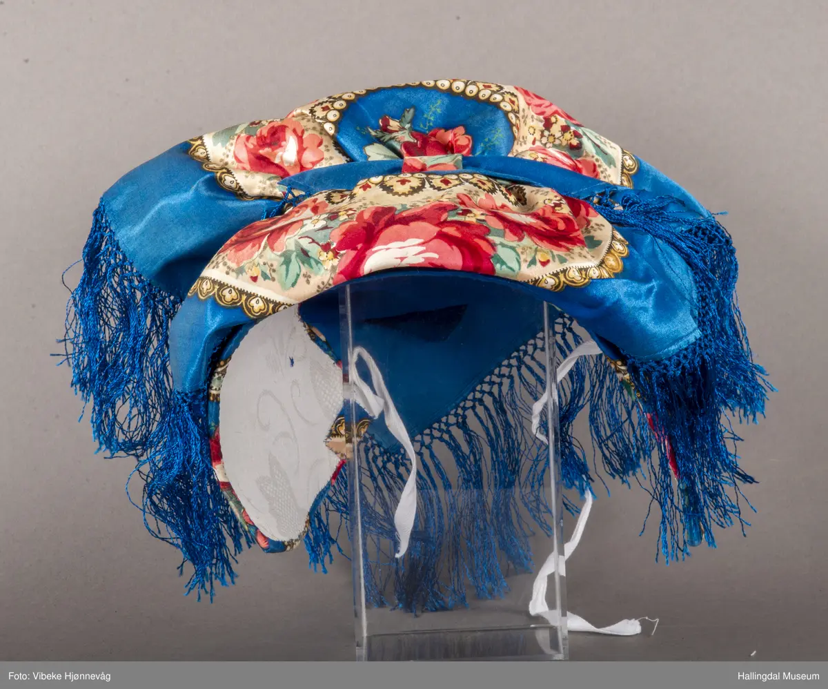 Halvsilkesateng. Sydd, trykt, kvit stiva heklet knipling. Blå bunnfarge, påtrykt blomster i alle farger.