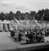 Jubileumsutställningen. Invigningen. 
Vy över de församlade på skolgården till Växjö Högre Allmänna Läroverk. 
Man ser en mängd lottor och bakom dem en manskör.