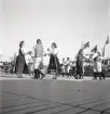 Jubileumsutställning. 
Folkdansuppvisning. Ett folkdanslag i Värendsdräkt m.m. visar upp
sig på en dansbana.