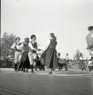 Jubileumsutställning. 
Folkdansuppvisning. Ett folkdanslag i Värendsdräkt m.m. visar upp
sig på en dansbana.