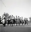 Jubileumsutställning. 
Folkdansuppvisning. Ett folkdanslag i Värendsdräkt m.m. visar upp
sig på en dansbana.