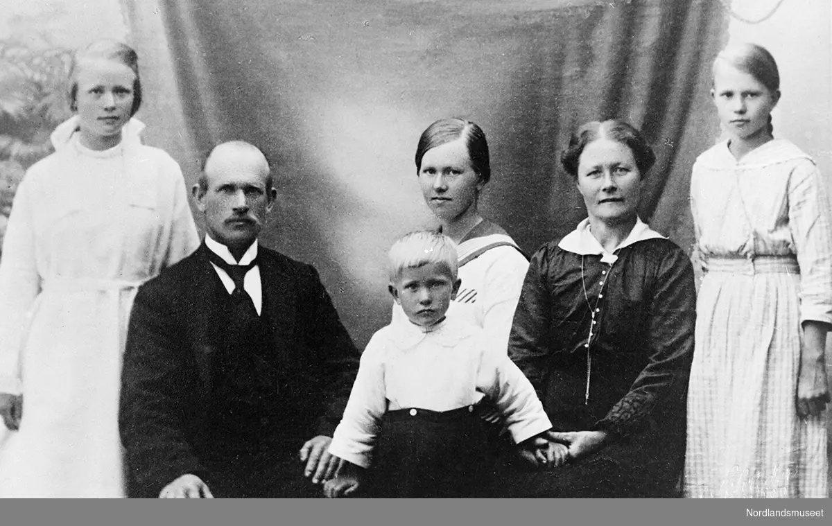 Portrett av en kvinne, en mann, tre piker og en gutt. Familien Bjørnø: far Olaf og mor Petra og deres fire barn, jentene fra venstre: Ingvarda, Gurine, Petra. Bjarne står foran mellom mor og far.