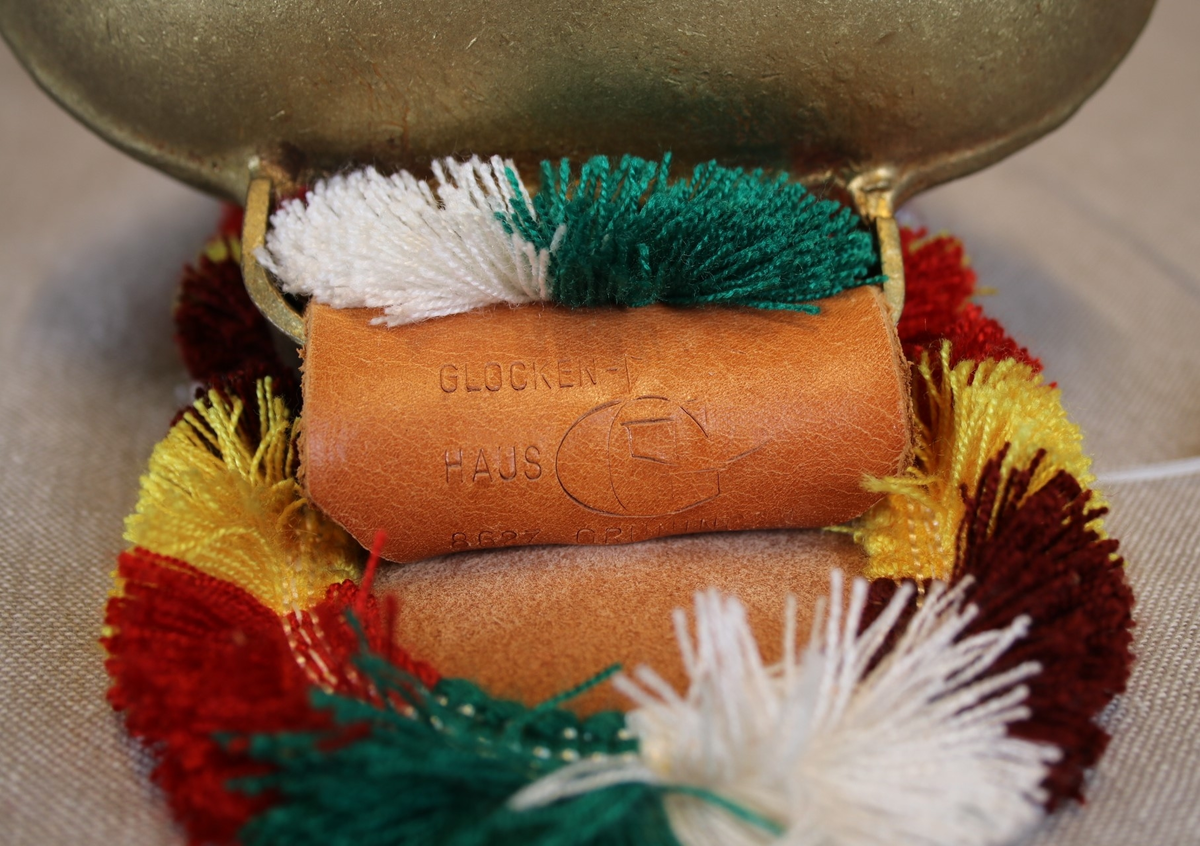 Våpenskjold med det sveitsiske flagget, et seterlandskap, en fjellvandrer og kyr.