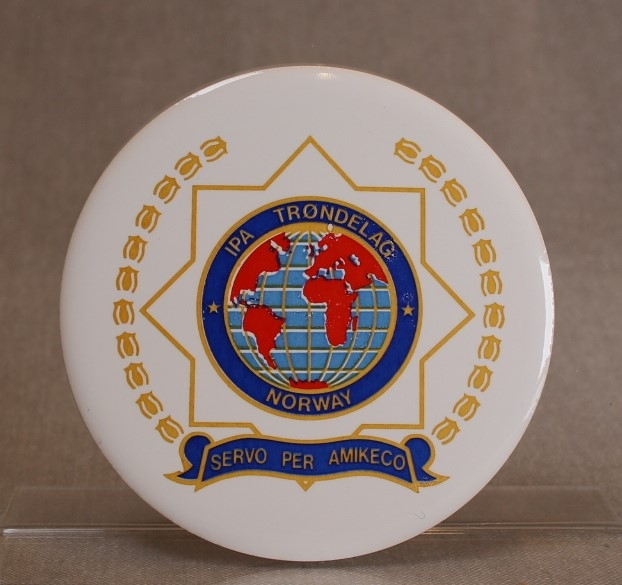 Runde, hvite porselensplaketter påtrykt IPAs emblem og motto.