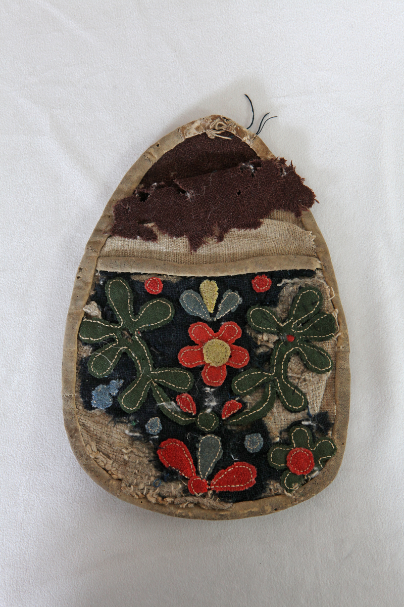 Ur gamla samlingar.
Epok 1 1907-1922 Bricken Gyllenhammar
Väska "Lomma". Kläde och fårskinn. Mönstret består av applikationer med lintråd. 
Enligt lapp i väskan, skriven av Ruth Jonsson,  är väskan skänkt till Bollnäs Hemslöjdsförenings samlingar av textillärare Britta Ekstrand och har ursprungligen kommit från Olof Mickelsson i Böle, Hanebo. 

Reg. av: R.J. (Ruth Jonsson), I.P. (Ingegerd Persson).