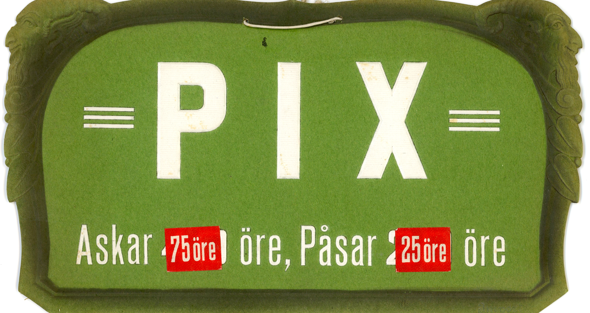 Reklamskylt för Pix-tabletter, tillverkad av tunnare kartong (en hängande modell). I nederkanten anges priser för Pix-askar och påsar (75 öre / 25 öre). Färgschemat består av en grön bakgrund med vit text. Samlingen inkluderar två (2) skyltar, som förvaras i den ursprungliga arkivlådan som givaren har tillhandahållit.
