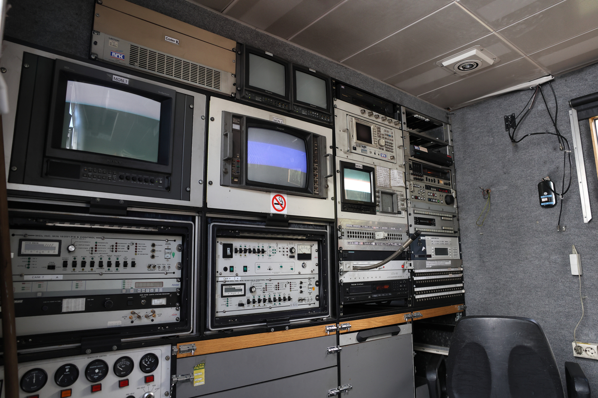 Dette er produksjonsrommet i en OB-buss, også kalt regirommet. Dette er der regissører, teknikere og produsenter styrer og overvåker de ulike kameraene, lyd og videosignalene, og hvor selve live-produksjonen koordineres. Her finnes typisk monitorer, miksebord for lyd og bilde, samt annet teknisk utstyr som brukes for å styre sendingen (Chat GPT)