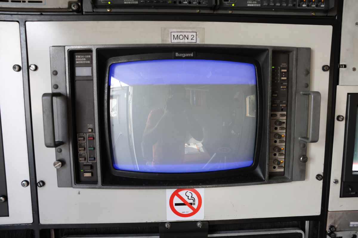 Dette er produksjonsrommet i en OB-buss, også kalt regirommet. Dette er der regissører, teknikere og produsenter styrer og overvåker de ulike kameraene, lyd og videosignalene, og hvor selve live-produksjonen koordineres. Her finnes typisk monitorer, miksebord for lyd og bilde, samt annet teknisk utstyr som brukes for å styre sendingen (Chat GPT)