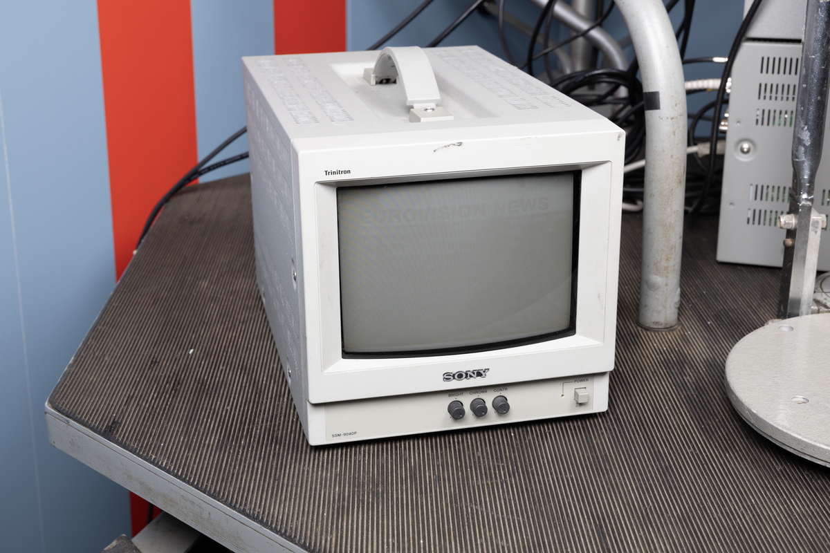 Teleskopisk mikrofonbom med ca.6 meters rekkevidde. Når den slås ut holdes den oppe av en motvekt for å være i balanse. Heises ut og inn alt etter behov. Plassert på bord med hjul og sete for operatør, samt tilhørende monitorer.