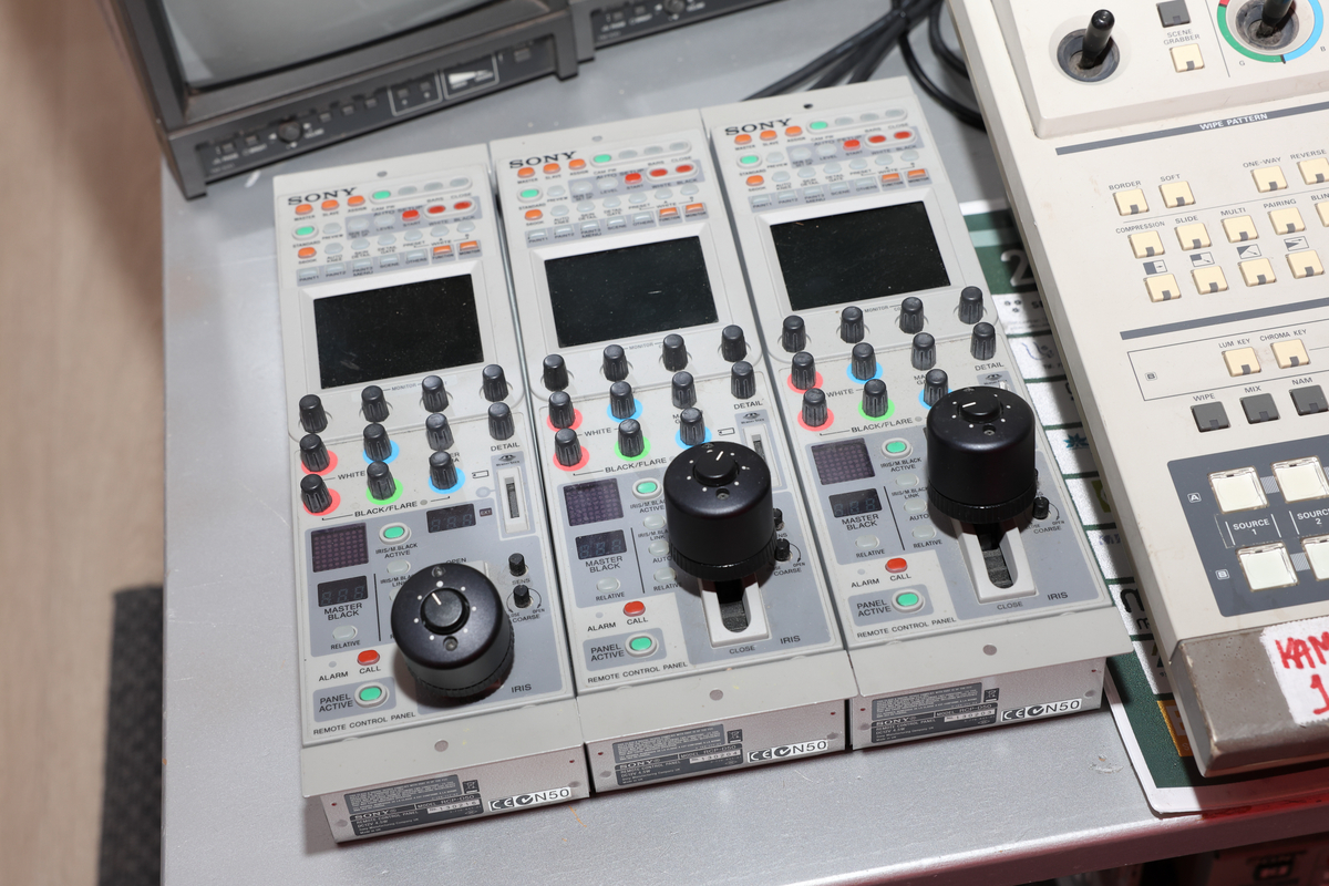 Studio med miksebord og monitorer og separat rack med lydmikser.