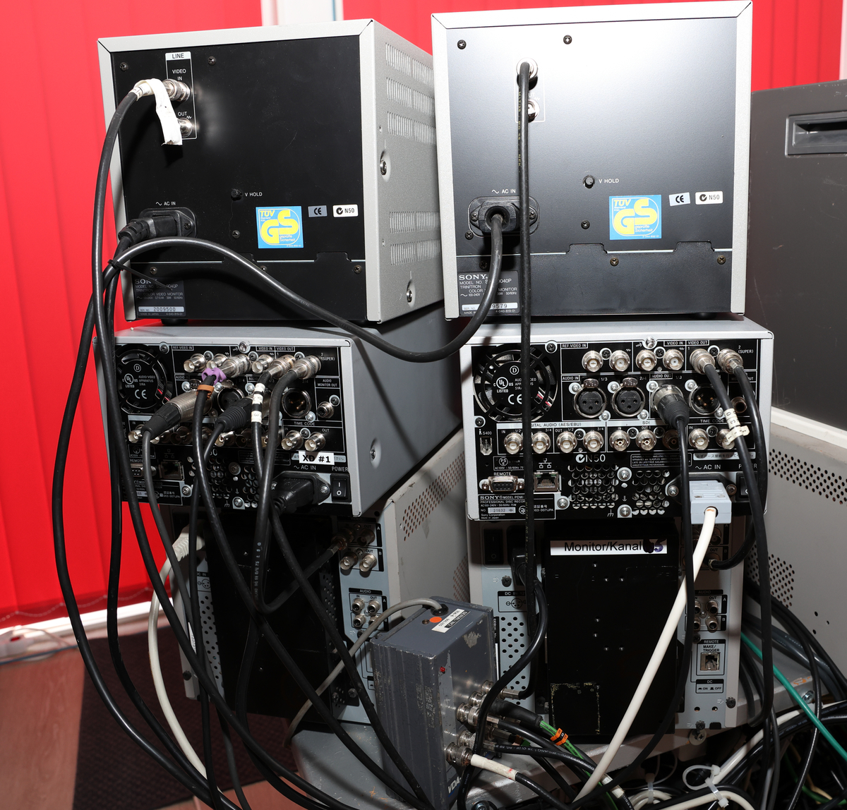 Studio med miksebord og monitorer og separat rack med lydmikser.