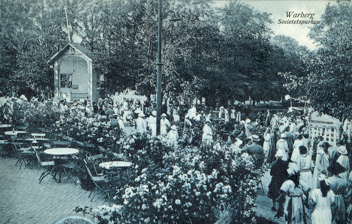 Blåtonat vykort, "Warberg. Societetsparken." Vy från societetsrestaurangen parken med musikpaviljongen och församlade människor nedanför terrassen.