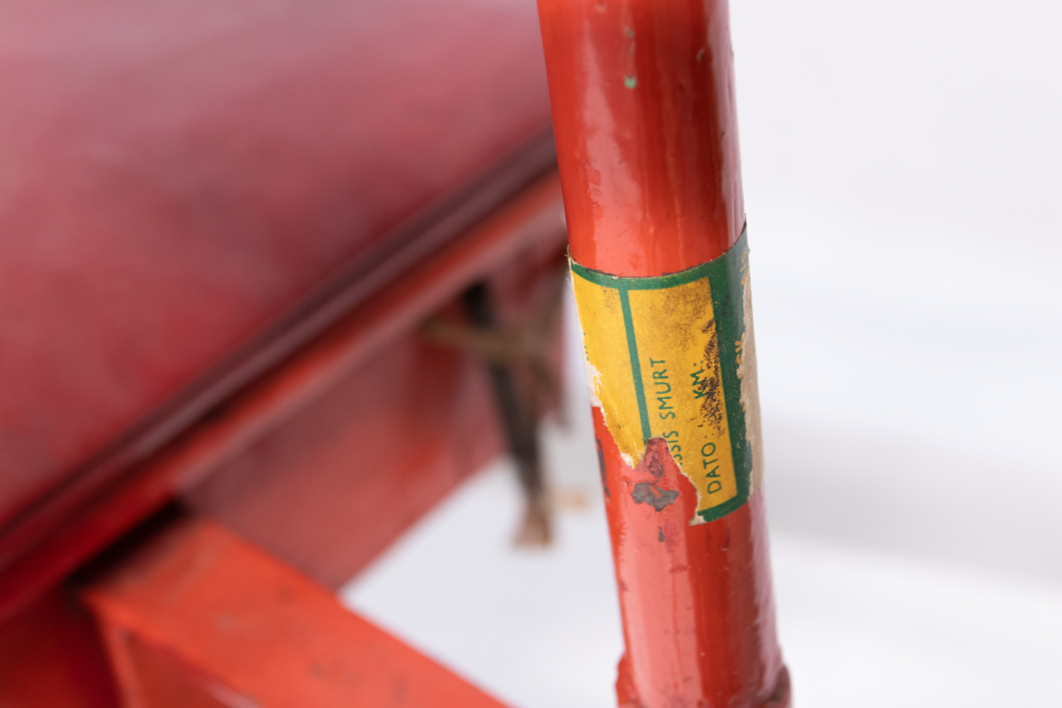 Rød metallsykkel med trehjul og lasteplan.