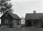 Här sitter Petter Boberg 80 år gammal på trappan till den lilla manbyggnaden, vilken han sålde efter det att bilden togs. Stället verkar lite övergivet, den nyare byggnaden till vänster innehållande brygghus, snickarbod mm (?) verkar aldrig ha blivit riktigt färdigställd och stod här oanvänd. Trädgården är obefintlig så när som på någon buske och träd, vilket var vanligt förr även på välmående gårdar, se de flesta bilder av manbyggnader eller gårdsmiljöer.

Bostadshuset är en inpanelad bulstuga innehållande två rum, en liten vardagsstuga till vänster med kanske ett obetydligt kök på baksidan och en 