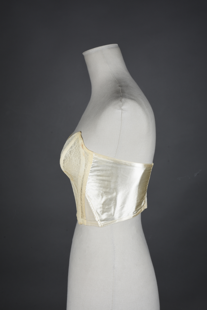 Brystholder med spiler. Lang i formen og kan minne om et korsett. Lukkes bak med hekter.