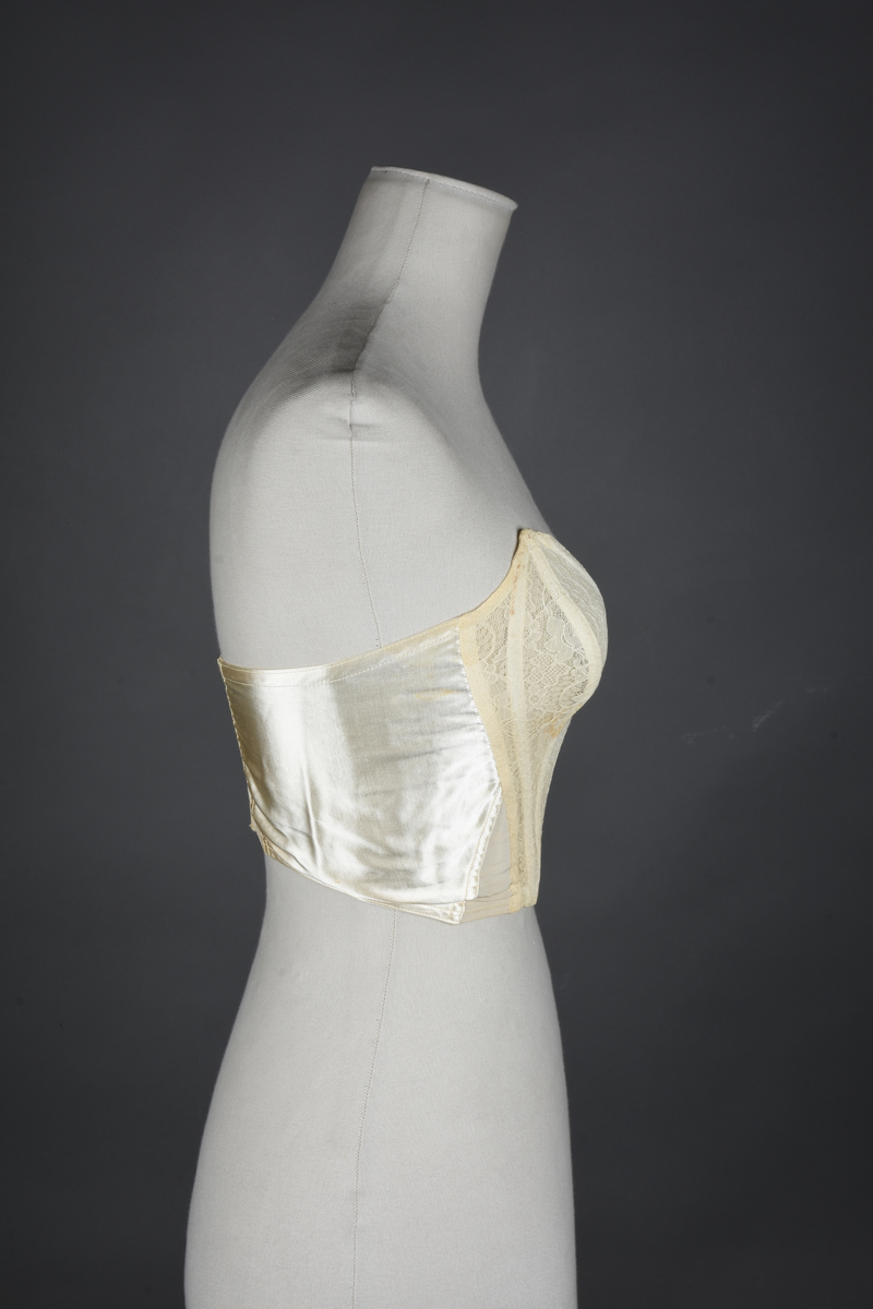 Brystholder med spiler. Lang i formen og kan minne om et korsett. Lukkes bak med hekter.