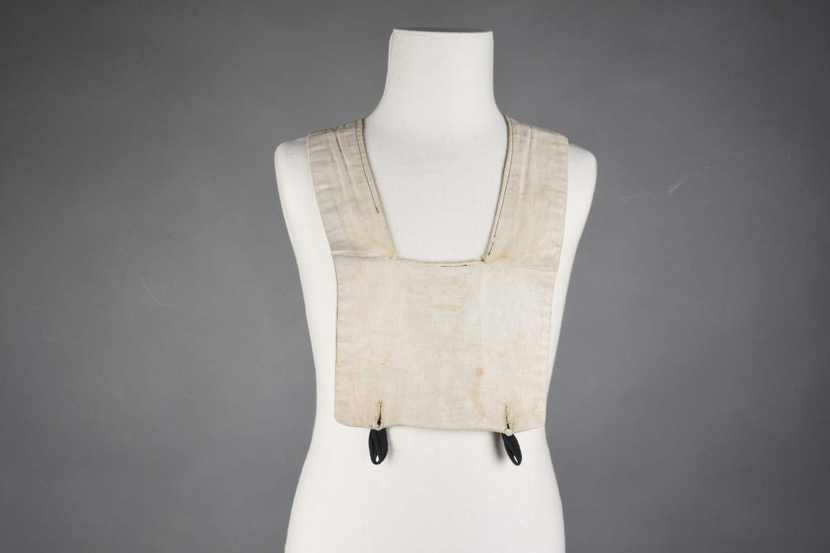 Matrosdress av ull og bomull. Bluse (A), benklær (B), livstykke (C) og matroskrave (D). Bluse med rett form og snøring i halsen. Legg på ermene. Lomme med rødt lommetørkle. Rød snor om skulder, Flagg- og våpenmerke. Benklær/bukse er åpen med knapp i begge sidene. Knelengde. Tre knappper på hvert bein, seks oventil. Grått livstykke til å feste buksen på. Knapphull og hemper. Matroskrave av mørkeblå silke med fire hvite striper langs den ytre kanten. To sorte bendel-knytebånd.