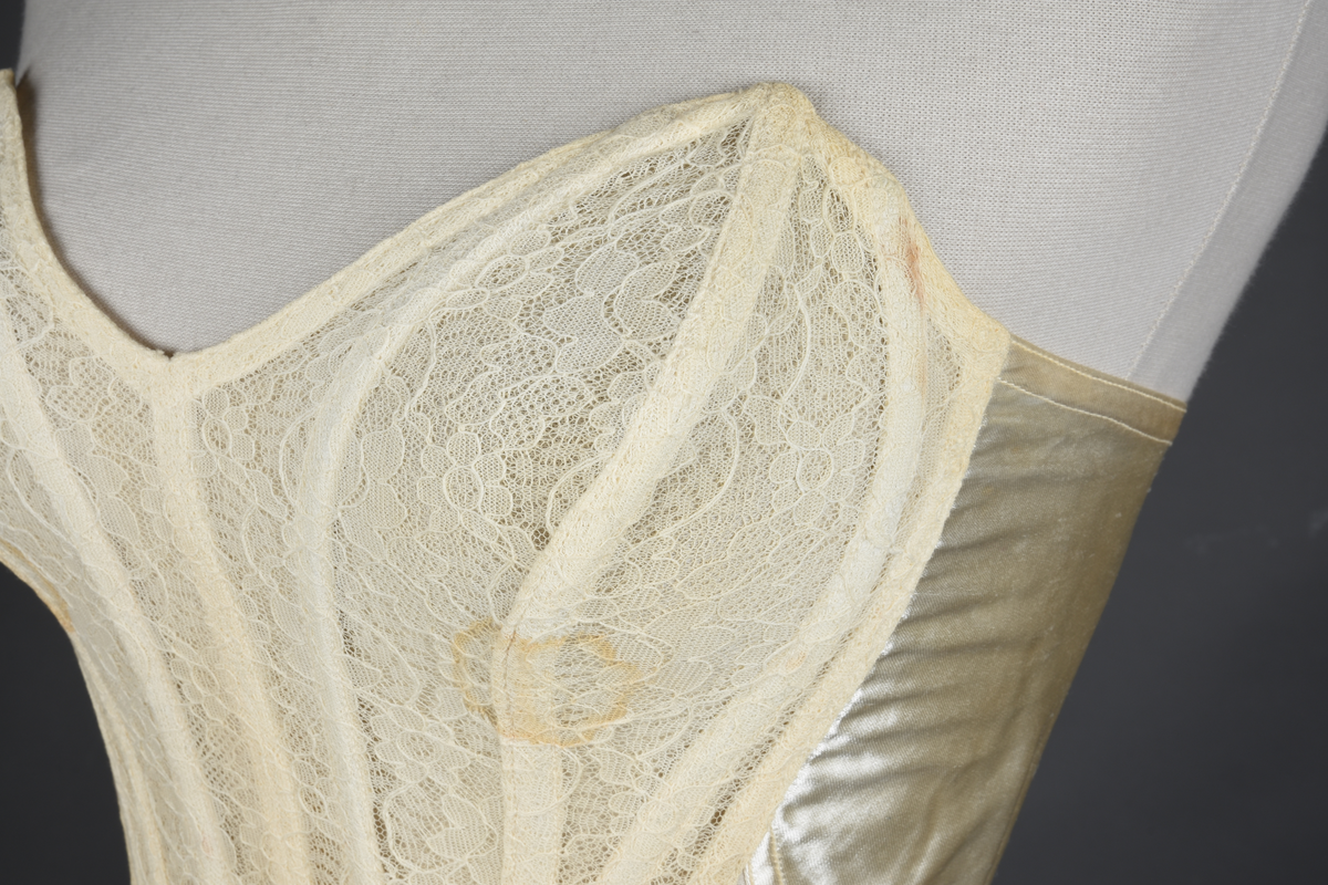 Brystholder med spiler. Lang i formen og kan minne om et korsett. Lukkes bak med hekter.