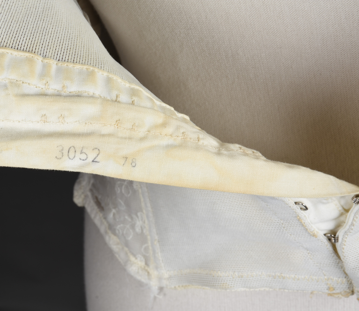 Brystholder av blondestrikk, med spiler. Både korsettspiler og cup-spiler. Lang form. Lukkes bak med hekter.