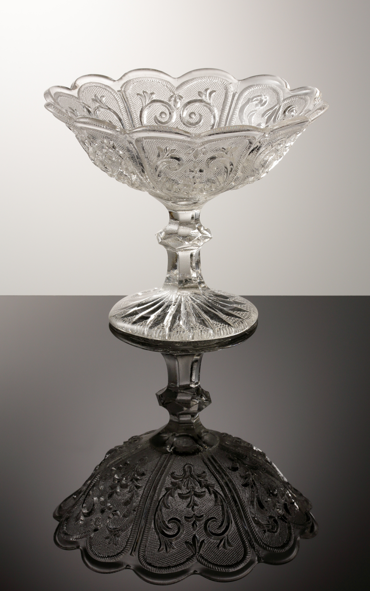 Skål, på ben och fot.
Pressad.
Klarglas.
Inpressat "Å".